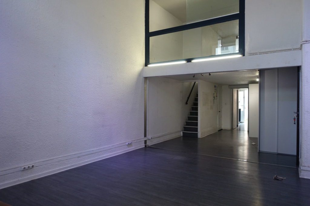 local commercial avec parquet et papier peint exotique verrière et appliques en rotin